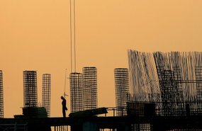File - In this Aug. 6, 2008 file photo a worker pauses at dusk on top of a building under construction in Bucharest, Romania.   Romania's sorry real estate saga is a reflection of the headwinds from the global economic turmoil still facing Eastern Europe,